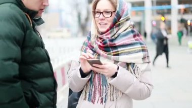 Boş şehir gquere arka planda sabahın erken saatlerinde ayakta güzel mutlu kız portresi. Sevimli kız bir harita üzerinde bir rota kontrol ederken bir cep telefonu içine bakar. Gerçek insanlar serisi.