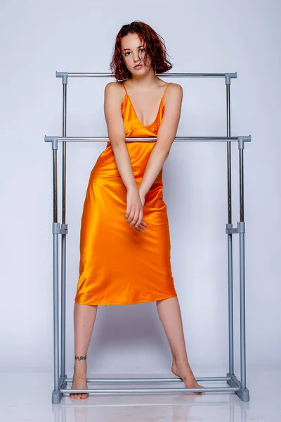 스튜디오에서 오렌지 드레스를 매력적 여자의 매력적 — 스톡 사진