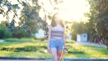 Spor, yaşam tarzı, Extreme and people konsepti, güneşli havada şehirde yollarda güzel bir kız. Günbatımında uzun bir sörf tahtasıyla gülümseyen hippi kız portresi. Yavaş çekim