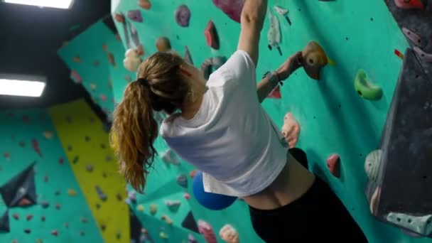 フィットネス 極端なスポーツ ボルダリング 人々と健康的なライフスタイルの概念 屋内クライミングジムの壁で運動若い女性 — ストック動画