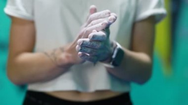 Fitness, ekstrem sporlar, kayalar, insanlar ve sağlıklı yaşam tarzı konsepti - kadın içeride yapay duvarda kaya tırmanışı yapıyor. Kaya tırmanışı. Magnezyumlu kişilerin ellerinin detayları.