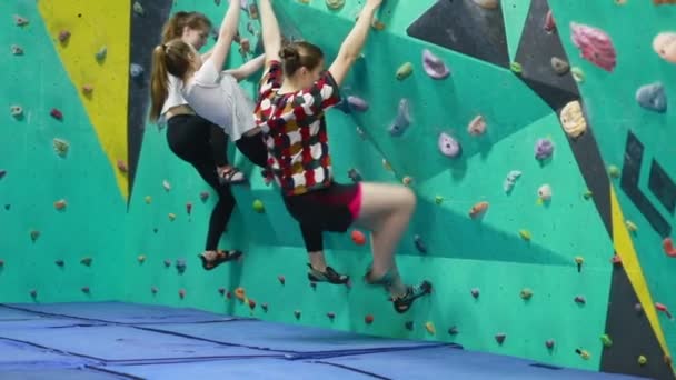 极限运动 人和健康的生活方式的概念 三个女人正在爬上人造的墙 职业女性攀登者在室内攀岩 享受极度休闲 — 图库视频影像