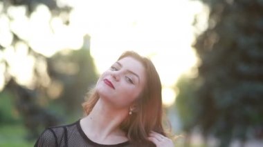 Çekici bir portre, güneş ışığı, saçları olan gülümseyen genç bir kadın, gülümse, gülümse, gülümse, gülümse, yaz, gün batımına bak.