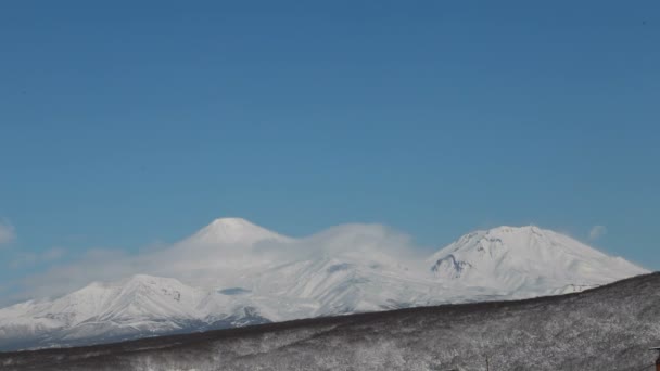 カムチャツカ時間の経過 空を横切って漂流し コルヤク火山の円錐形の美しい雲の背景にペトロパブロフスク カムチャツキー市の上のビュー コルヤスキー火山 カムチャツカ半島 ロシア極東 — ストック動画