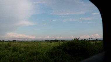 Hareket halindeki bir trenin yolcu görüntüsü. Zaman geçirmeyi hayal ediyorum. Trenin penceresinden hızlandırılmış video.