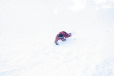 Kış, eğlence, spor ve insan konsepti. Snowboardcu karda kaza yaptı. Snowboardcu taze karın üstüne düşüyor.