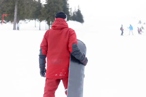 体育和人的概念 戴着头盔的雪人站在山顶上 背着雪板 — 图库照片
