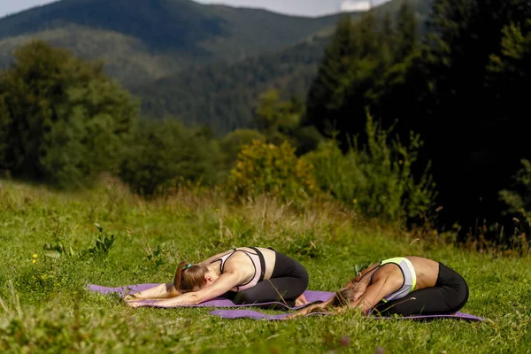 Dos Mujeres Haciendo Yoga Parque Mujeres Practicando Pose Infantil Mientras — Foto de Stock