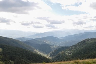 Dağlarda yaz manzarası ve bulutlu koyu mavi gökyüzü. Romanya 'daki Güney Karpatlar' ın bir parçası olan Bucegi Dağları 'ndan manzara çok sisli bir günde