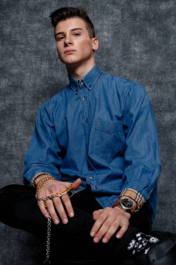 Kot gömlekli adam, kolları kalçasında, gri arka planı var. İnsanların yaşam tarzı konsepti. Kopyalama alanı oluşturun. Kolları düzeltiyorum. Hazır ol.