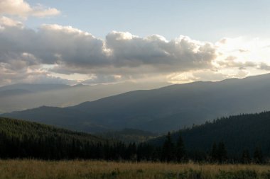 Dağlarda yaz manzarası ve bulutlu koyu mavi gökyüzü. Romanya 'daki Güney Karpatlar' ın bir parçası olan Bucegi Dağları 'ndan manzara çok sisli bir günde