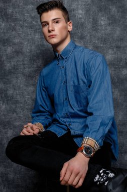 Kot gömlekli adam, kolları kalçasında, gri arka planı var. İnsanların yaşam tarzı konsepti. Kopyalama alanı oluşturun. Kolları düzeltiyorum. Hazır ol.