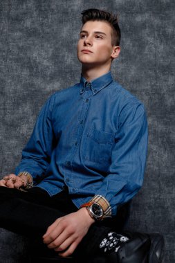 Kot gömlekli adam, kolları kalçasında, gri arka planı var. İnsanların yaşam tarzı konsepti. Kopyalama alanı oluşturun. Kolları düzeltiyorum. Hazır ol.