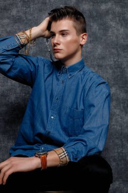 Kot gömlekli adam, kolları kalçasında, gri arka planı var. İnsanların yaşam tarzı konsepti. Kopyalama alanı oluşturun. Kolları düzeltiyorum yana bakıyorum.