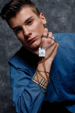 Kot gömlekli adam, kolları kalçasında, gri arka planı var. İnsanların yaşam tarzı konsepti. Kopyalama alanı oluşturun. Kolları düzeltiyorum. yüzünüzü kapatın.