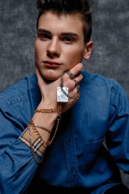 Kot gömlekli adam, kolları kalçasında, gri arka planı var. İnsanların yaşam tarzı konsepti. Kopyalama alanı oluşturun. Kolları düzeltiyorum. yüzünüzü kapatın.