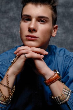 Kot gömlekli adam, kolları kalçasında, gri arka planı var. İnsanların yaşam tarzı konsepti. Kopyalama alanı oluşturun. Kolları düzeltiyorum. yüzünüzü kapatın.