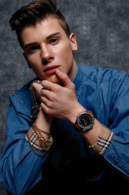 Kot gömlekli adam, kolları kalçasında, gri arka planı var. İnsanların yaşam tarzı konsepti. Kopyalama alanı oluşturun. Kolları düzeltiyorum. yüzünüzü kapatın.