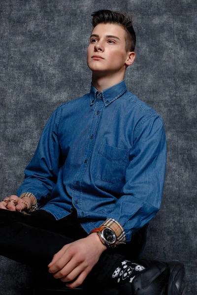 Kot gömlekli adam, kolları kalçasında, gri arka planı var. İnsanların yaşam tarzı konsepti. Kopyalama alanı oluşturun. Kolları düzeltiyorum. Hazır ol.