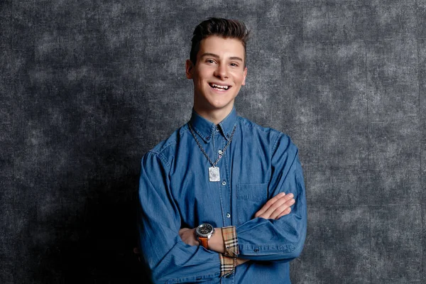 Kot gömlekli adam, kolları kalçasında, gri arka planı var. İnsanların yaşam tarzı konsepti. Kopyalama alanı oluşturun. Kolları düzeltiyorum. Gülümse