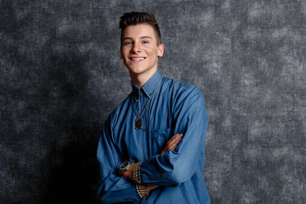 Kot gömlekli adam, kolları kalçasında, gri arka planı var. İnsanların yaşam tarzı konsepti. Kopyalama alanı oluşturun. Kolları düzeltiyorum. Gülümse