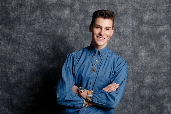 Kot gömlekli adam, kolları kalçasında, gri arka planı var. İnsanların yaşam tarzı konsepti. Kopyalama alanı oluşturun. Kolları düzeltiyorum. Gülümse