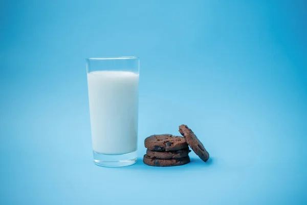 餐桌上放巧克力片和一杯牛奶的饼干 — 图库照片