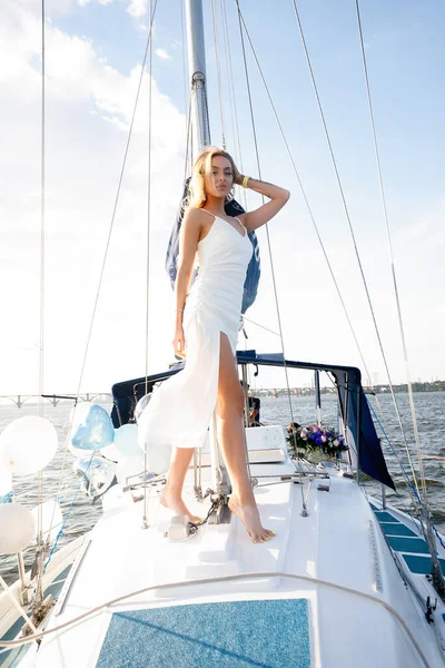 ドレスやメイクで美しい若いセクシーなブロンドの女性 風の湾の海や海の上に白い帆とヨットで夏の旅と太陽の風はロマンチックな日焼け — ストック写真