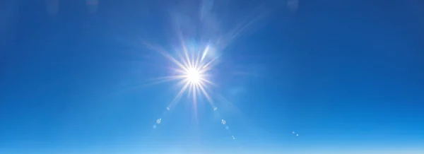 Небесный фон с солнечными лучами на ярко-голубом небе — стоковое фото