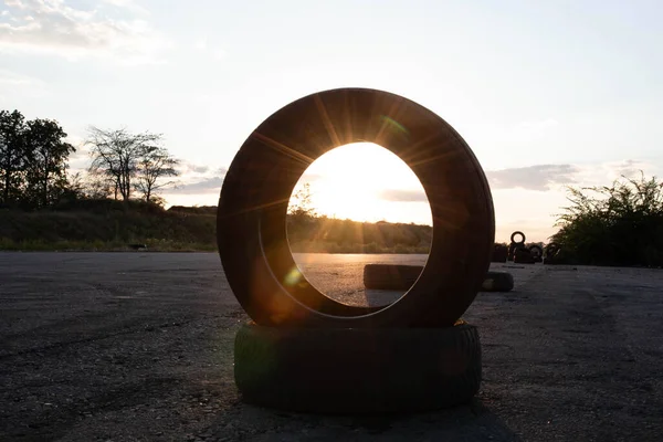 Gün batımında güneş. Araba lastikleri. Yol