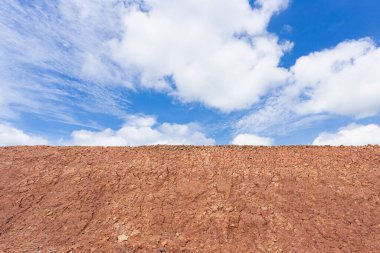 Çatlak çöl toprağının üzerinde bulutlar olan mavi gökyüzünün arka plan manzarası
