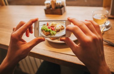 Eller adamın telefon ve leziz yemek alarak resmi plaka üzerinde tutuyor. Renkli ve lezzetli.