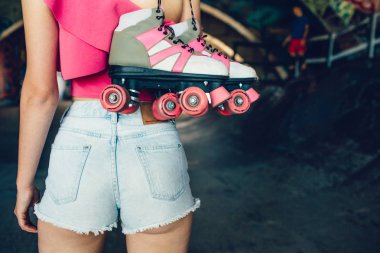 Çekici ve sıcak vücut ayakta ve silindirler sağ eli ile tutarak kızın resmi. Vücudu su kuyusu-yapılı ve ince.