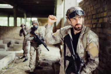 Genç ve sakallı adam ayakta bakıp doğru oldu. O ciddi ve konsantre. Adam yumruk yoldaşları için gösteriyor. Dur işaretidir. Diğer çocuklar için onların arkadaşları komut bekliyor.