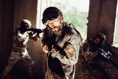 Sakallı adam karanlık bir odada duran ve yan arıyorum. O korkuyor. Adam silah elinde tutuyor. Diğer savaşçılar dışında pencerelerden bakarak ve territoty koruma.