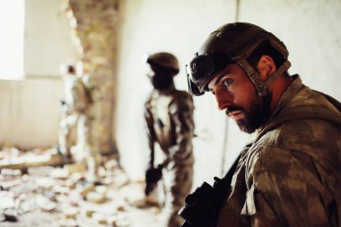 Sakallı asker ile yoldaşları harap bir odada duruyor. Çok yoğun. Adam dinliyor. Pencereye diğer savaşçılar daha fazla ve daha yakın duran.