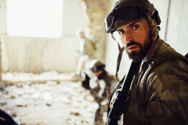 Ciddi ve cesaret adamı doğruca kameraya bakıyor. Endişeleniyor. Sana onun combads harap bir odada daha fazla ayakta mı. Bazı dinlenme ama çok dikkatli olmaya çalışıyorum.