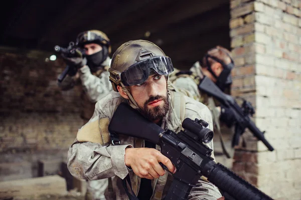 Una foto di guerrieri in piedi fuori. Si tengono i fucili e si sorvegliano a vicenda. Gli uomini stanno attenti. Sono sul campo di battaglia . — Foto Stock