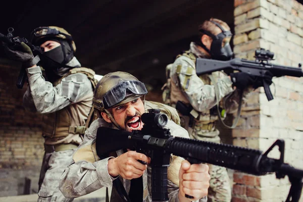 El hombre del frente emocional está afuera con sus soldados y gritando. Todos ellos tienen rifles negros. Son peligrosos. Los chicos están listos para pelear. . — Foto de Stock