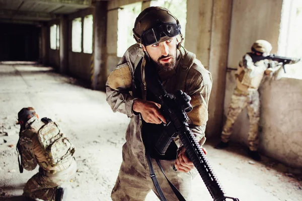 Ritratto di uomo in uniforme in piedi in camera vuota con altri soldati e in attesa. Sono molto prudenti. I ragazzi sono in pericolo e pronti ad iniziare una rissa . — Foto Stock