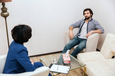 Yakışıklı ve rahat bir adam psikolog önünde oturan ve ona bakıyorsun. O çok emindir. Adam biraz gülümsüyor. O doktora dinliyor.