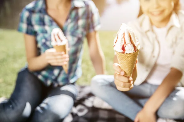 Uma foto de um delicioso gelado. Há dois contras dele na foto. As raparigas estão a segurá-lo. Pequeno está sorrindo . — Fotografia de Stock