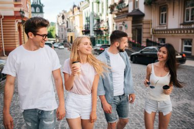 Neşeli genç insanlar sokakta yürüyor. Üç tane Çinli kız arıyor. O gözlük ve kahve elinde tutan. Hepsi gülümsüyor musun.