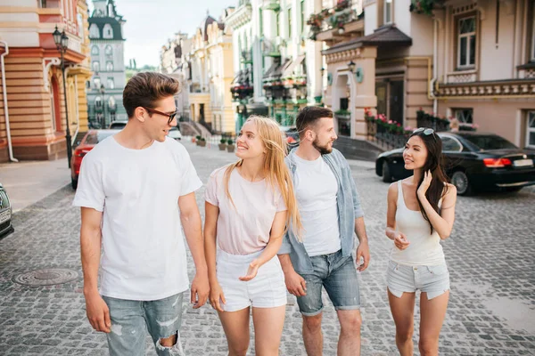 İki çiftler sokakta yürüyor. Gözlük ve sarışın kız adam önünde yürüyor. Onlar birbirine bakarak ve gülümseyerek. Arkasında başka bir çift yürüyüş.