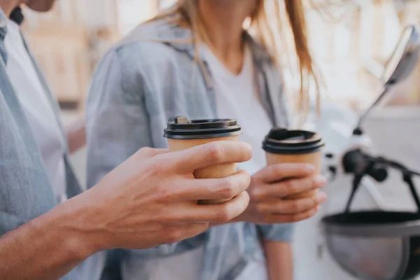 Großaufnahme von Jungs und Mädchen, die Tassen mit Kaffee in der Hand halten. Diese Menschen sitzen auf Motorrädern und ruhen sich aus. — Stockfoto