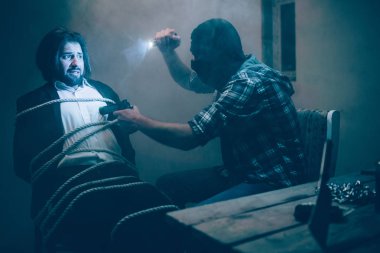 Dehşete sakallı adam ile ipler bağlanır. O ışıkta maskeli adam hlding olduğunu arıyor. Kaçıran kişi onun victom önünde oturan ve tabanca kurban göğüs için yakın koyarak.