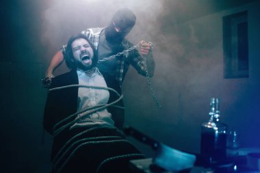 Esmer adam çığlık ve bağırıyor. O acı çekiyor. Maks içinde cesedi ile ipleri bağlıyor. Katil kurbanı arıyor