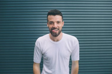 Komik adam tonge bir parça gösteriyor. O kameraya bakıyor ve gülümsüyor. Çizgili ve mavi arka plan izole.