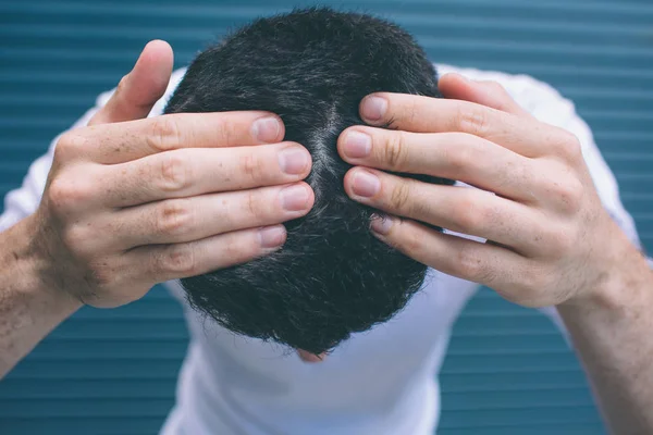 Uma foto de morena mostrando seu cabelo na cabeça. Ele está tocando-o com as mãos. O tipo tem problemas com o cabelo. Isolado em fundo listrado e azul . — Fotografia de Stock