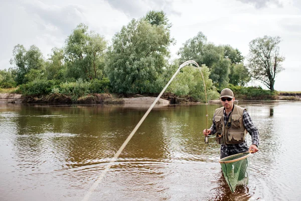 Balıkçı bir resim arıyorum ve sığ yalındır içinde duruyor. O el avlanma vardır. Bir kaşık kamerada gösterilir.